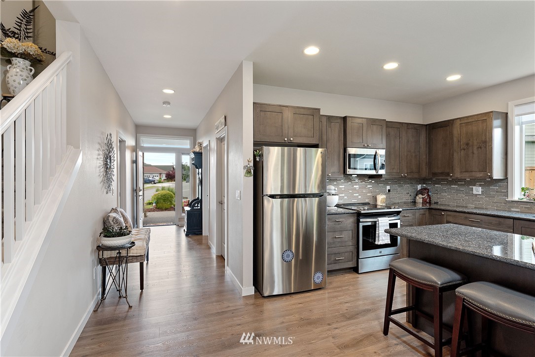 320 Blue Glacier Loop Sequim, WA 98382 - Photo 16 of 38 a kitchen with refrigerator a sink and chairs
