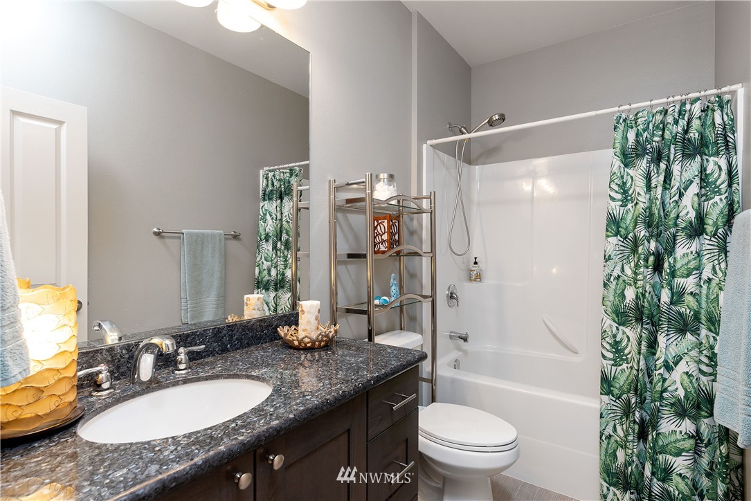 320 Blue Glacier Loop Sequim, WA 98382 - Photo 18 of 38 a bathroom with a granite countertop sink a toilet a large mirror and shower