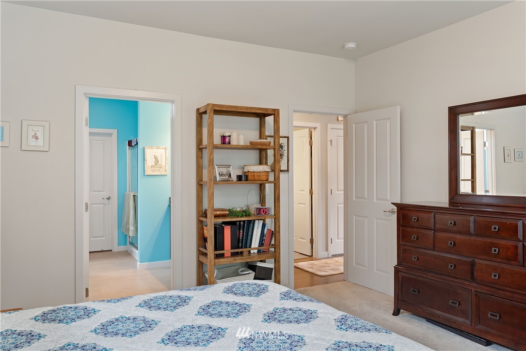 320 Blue Glacier Loop Sequim, WA 98382 - Photo 20 of 38 a bedroom with a bed and a dresser in it