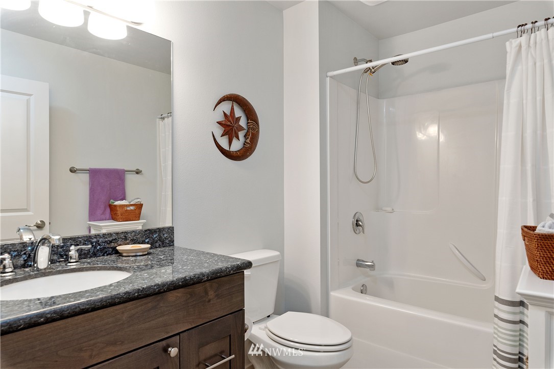 320 Blue Glacier Loop Sequim, WA 98382 - Photo 27 of 38 a bathroom with a granite countertop sink toilet a mirror and shower