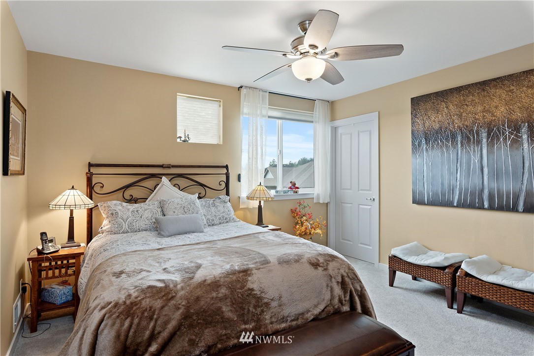 320 Blue Glacier Loop Sequim, WA 98382 - Photo 28 of 38 a bedroom with a bed and a chandelier