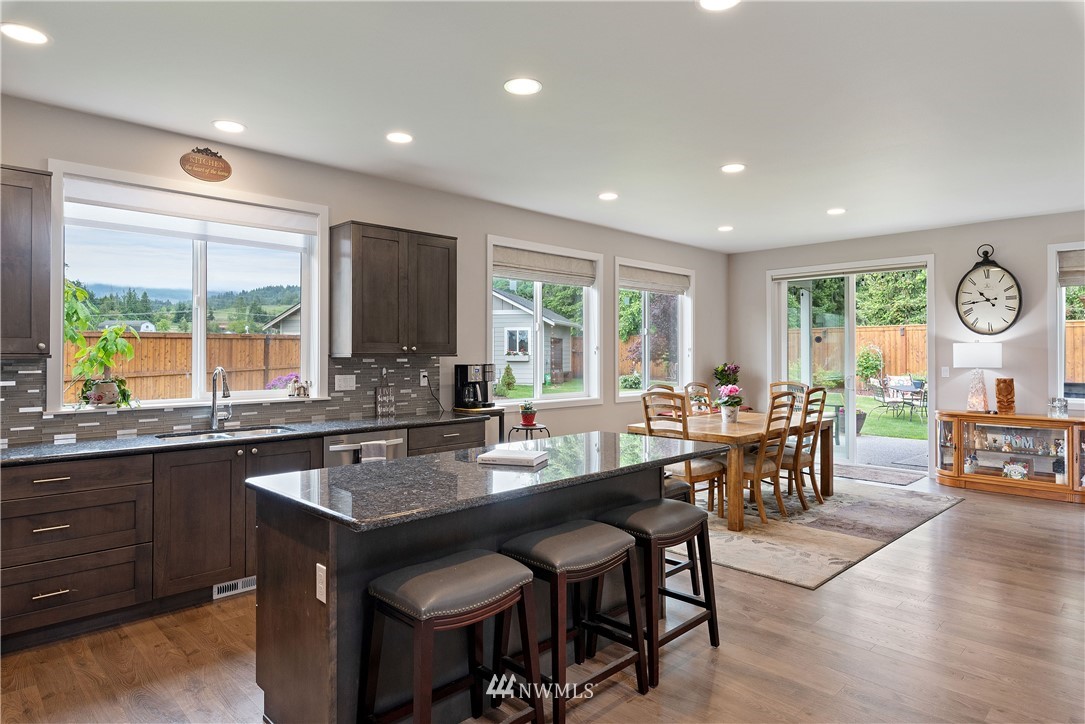 320 Blue Glacier Loop Sequim, WA 98382 - Photo 5 of 38 a kitchen with granite countertop a table and chairs in it