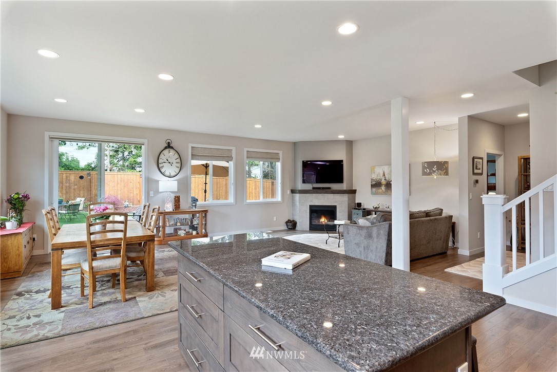 320 Blue Glacier Loop Sequim, WA 98382 - Photo 7 of 38 a kitchen with stainless steel appliances granite countertop a table chairs sink and cabinets