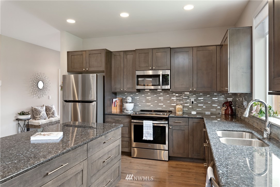 320 Blue Glacier Loop Sequim, WA 98382 - Photo 8 of 38 a kitchen with kitchen island granite countertop a sink cabinets and stainless steel appliances