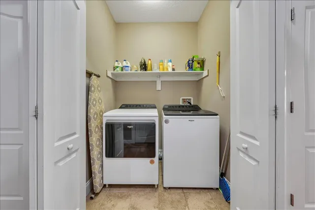 a view of pool with lawn chairs under an umbrella