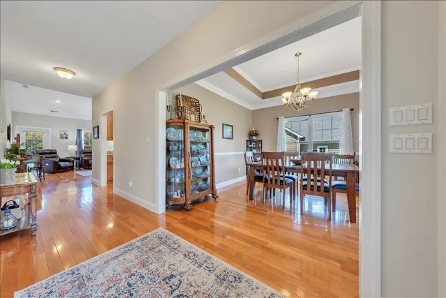 a kitchen with stainless steel appliances granite countertop a stove top oven a sink dishwasher a dining table and chairs with wooden floor