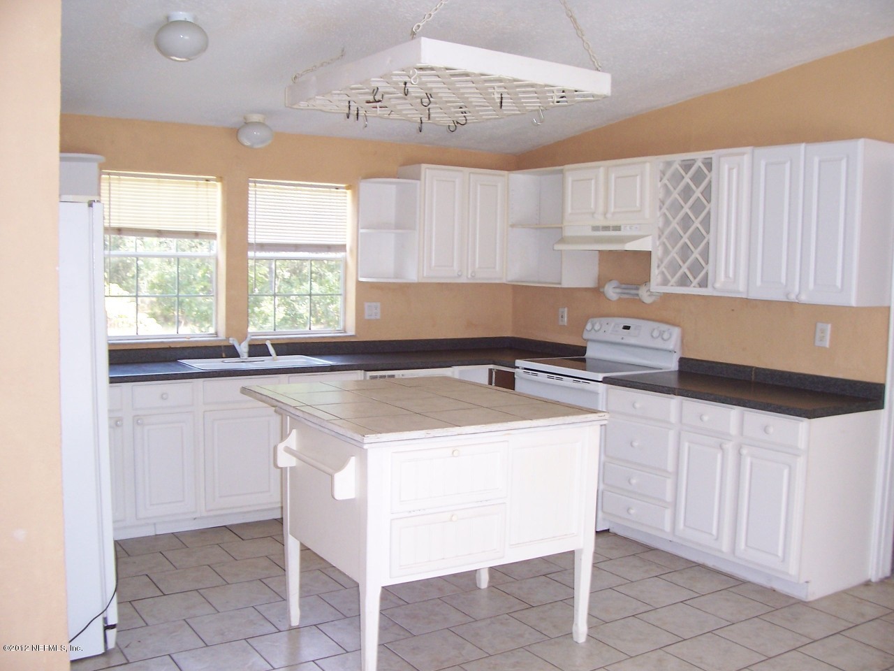 5671 Chugah Street Keystone Heights, FL 32656 - Photo 8 of 21 a kitchen with a sink a stove a microwave and cabinets