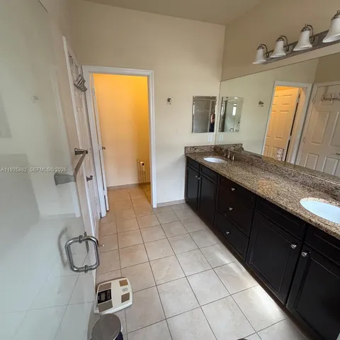 a spacious bathroom with a granite countertop sink a toilet and mirror