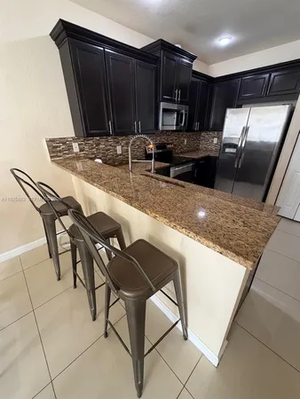a kitchen with kitchen island a counter top space appliances and cabinets