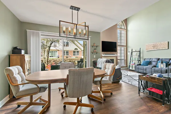 a view of a dining room with furniture a chandelier and wooden floor