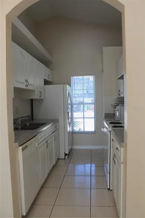 a kitchen with granite countertop a sink stove and cabinets