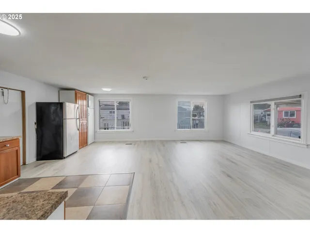 a view of an empty room with a kitchen