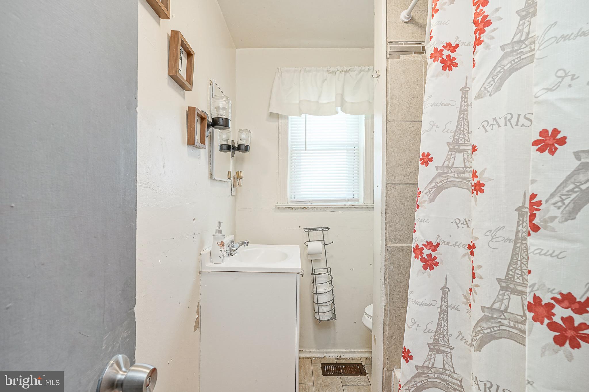 541 Randolph Street Camden, NJ 08105 - Photo 17 of 22 a bathroom with a sink vanity tub and a shower curtain