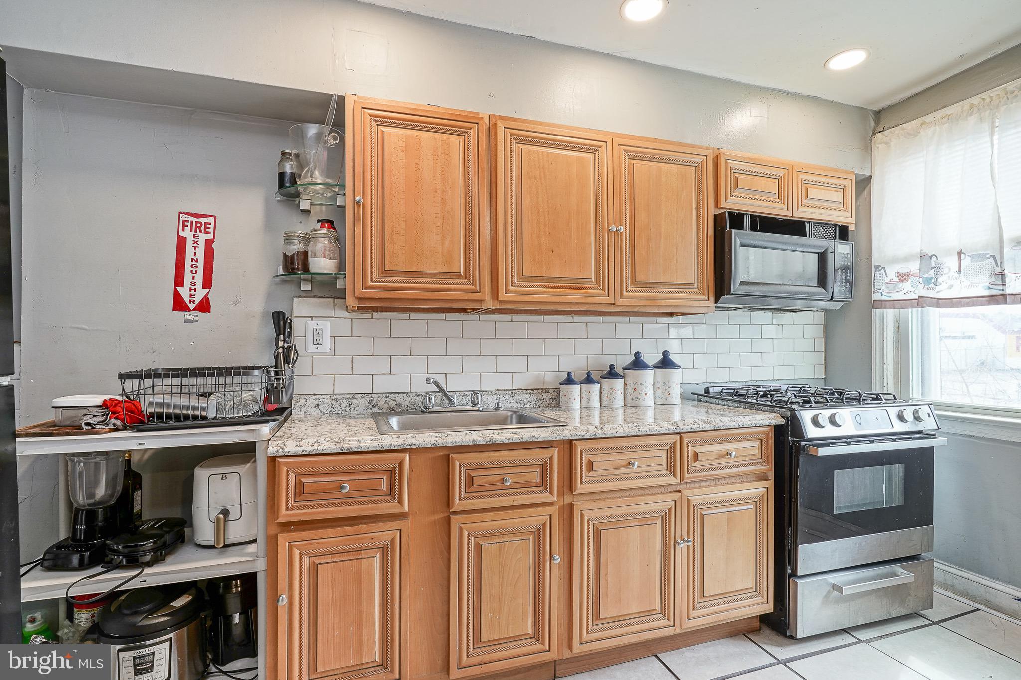 541 Randolph Street Camden, NJ 08105 - Photo 9 of 22 a kitchen with stainless steel appliances granite countertop a stove and cabinets