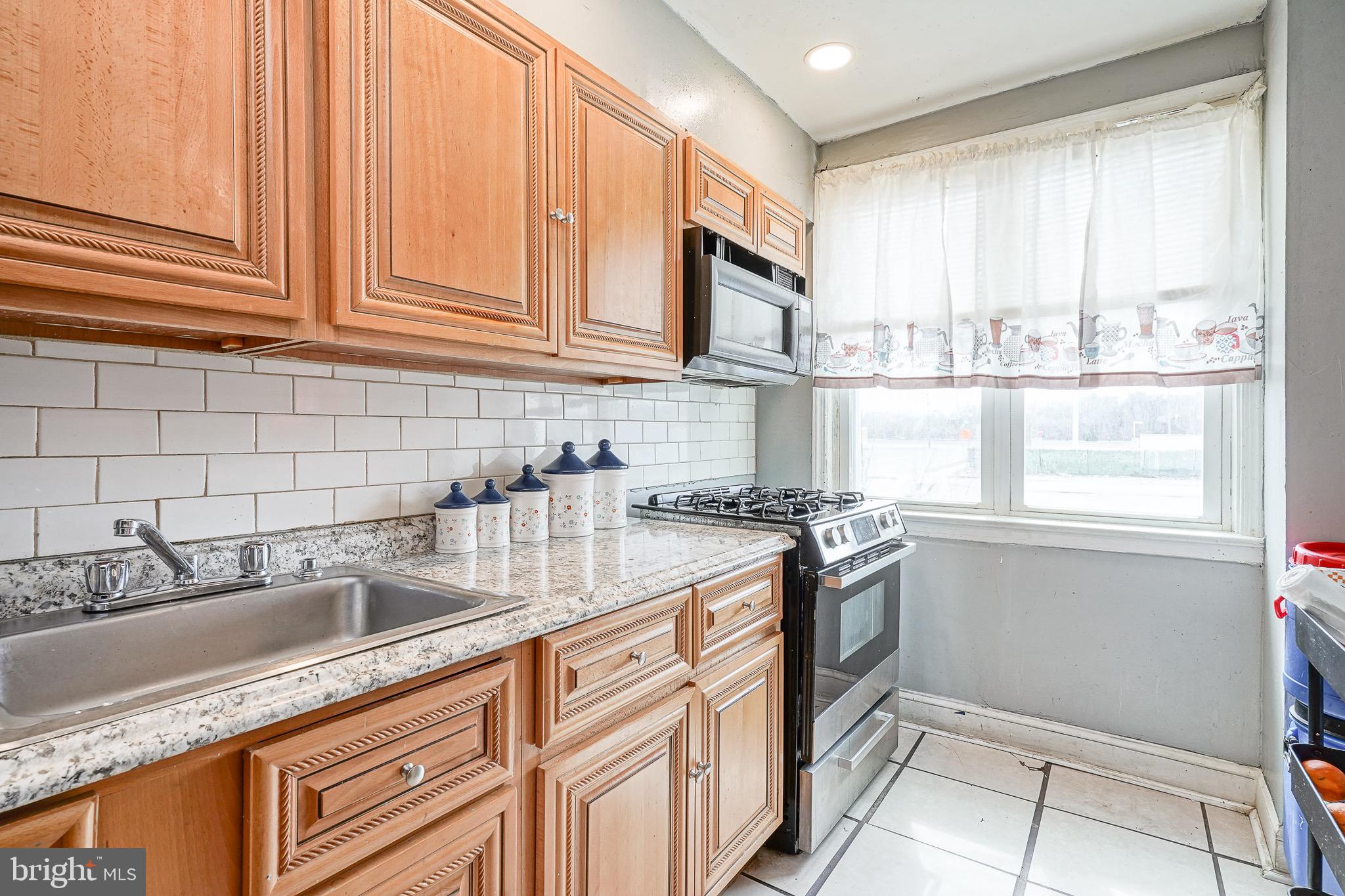 541 Randolph Street Camden, NJ 08105 - Photo 10 of 22 a kitchen with granite countertop a sink stainless steel appliances and cabinets