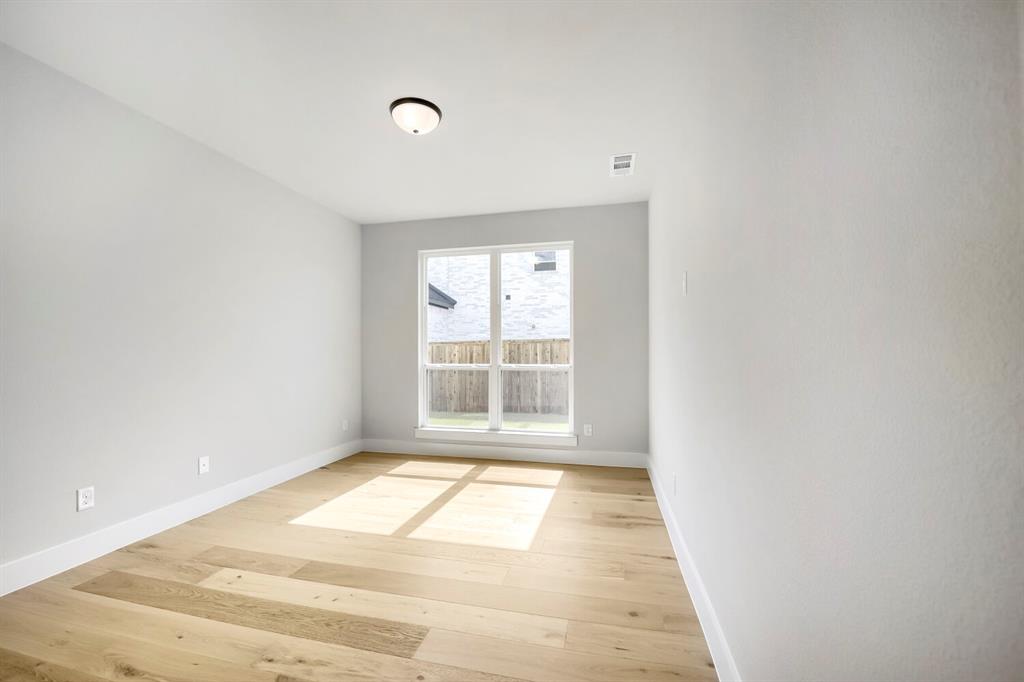 800 Blackberry Road Haslet, TX 76052 - Photo 12 of 28 Room featuring a large window, light wood-finish flooring, white baseboards, light neutral wall paint, and a flush-mount ceiling light fixture