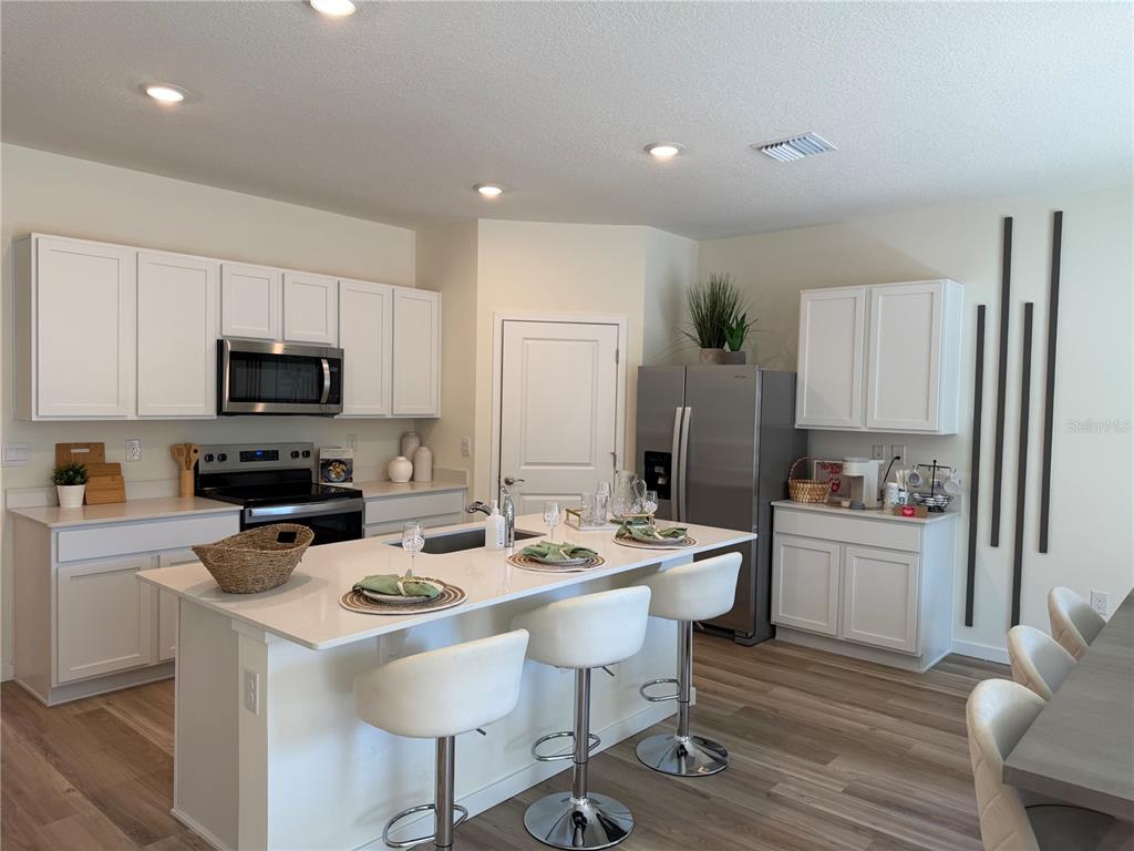 5326 Southwest 52nd Avenue Gainesville, FL 32608 - Photo 2 of 10 a kitchen with a sink a stove a refrigerator and white cabinets
