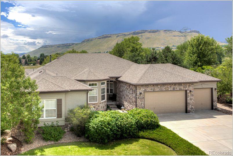 a aerial view of a house with a yard plants and large tree