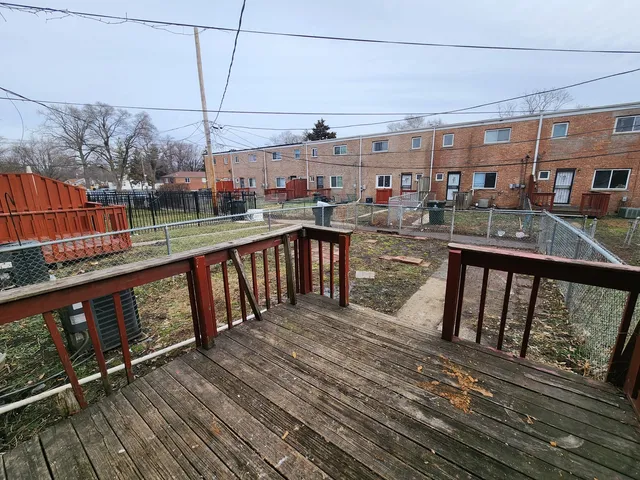 a view of a balcony with wooden floor and outdoor seating