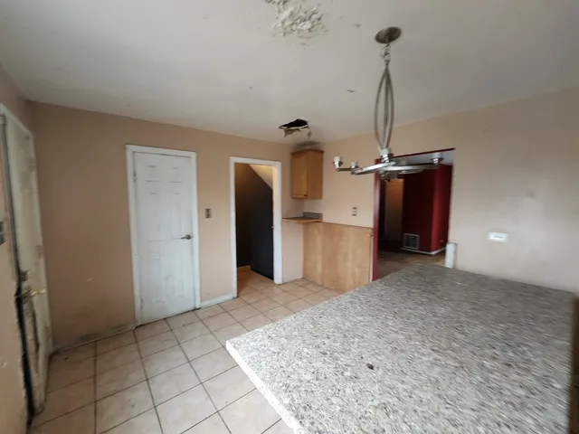 a view of empty room with a kitchen