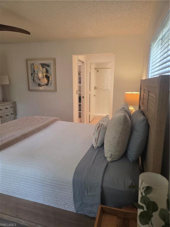 3531 County Barn Road, Unit C201 Naples, FL 34112 - Photo 12 of 20 Bedroom featuring a textured ceiling, a ceiling fan, and wood finished floors