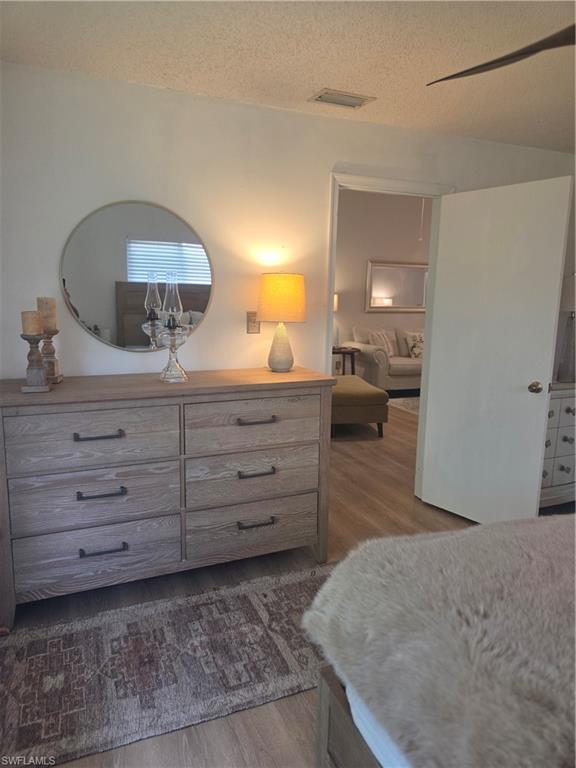3531 County Barn Road, Unit C201 Naples, FL 34112 - Photo 14 of 20 Bedroom with dark wood-type flooring and a textured ceiling