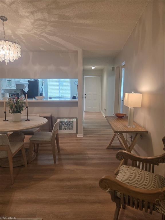 3531 County Barn Road, Unit C201 Naples, FL 34112 - Photo 4 of 20 Dining space featuring wood finished floors and a textured ceiling