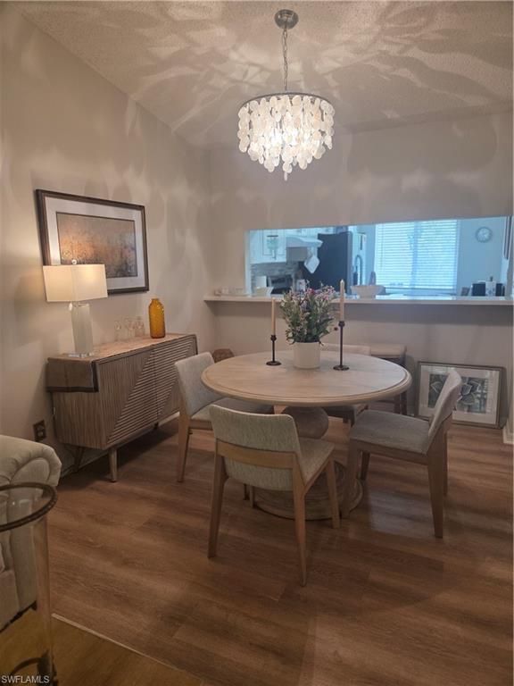 3531 County Barn Road, Unit C201 Naples, FL 34112 - Photo 5 of 20 Dining room featuring a textured ceiling, dark wood-style flooring, and a chandelier