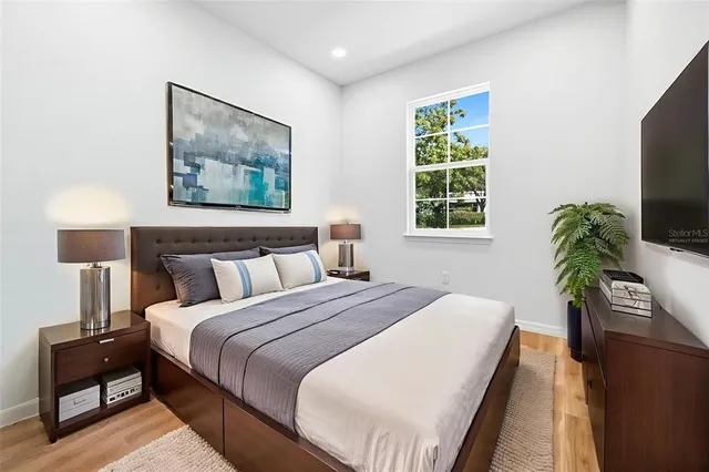 a bedroom with a bed and a flat screen tv