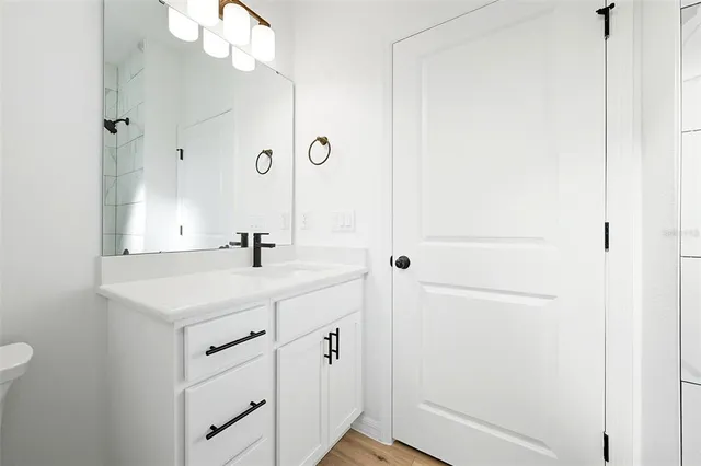 a bathroom with a sink vanity granite and a mirror