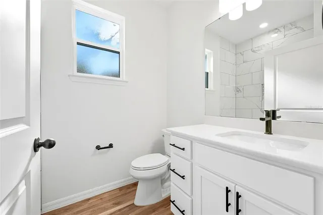 a bathroom with a sink a toilet and a mirror