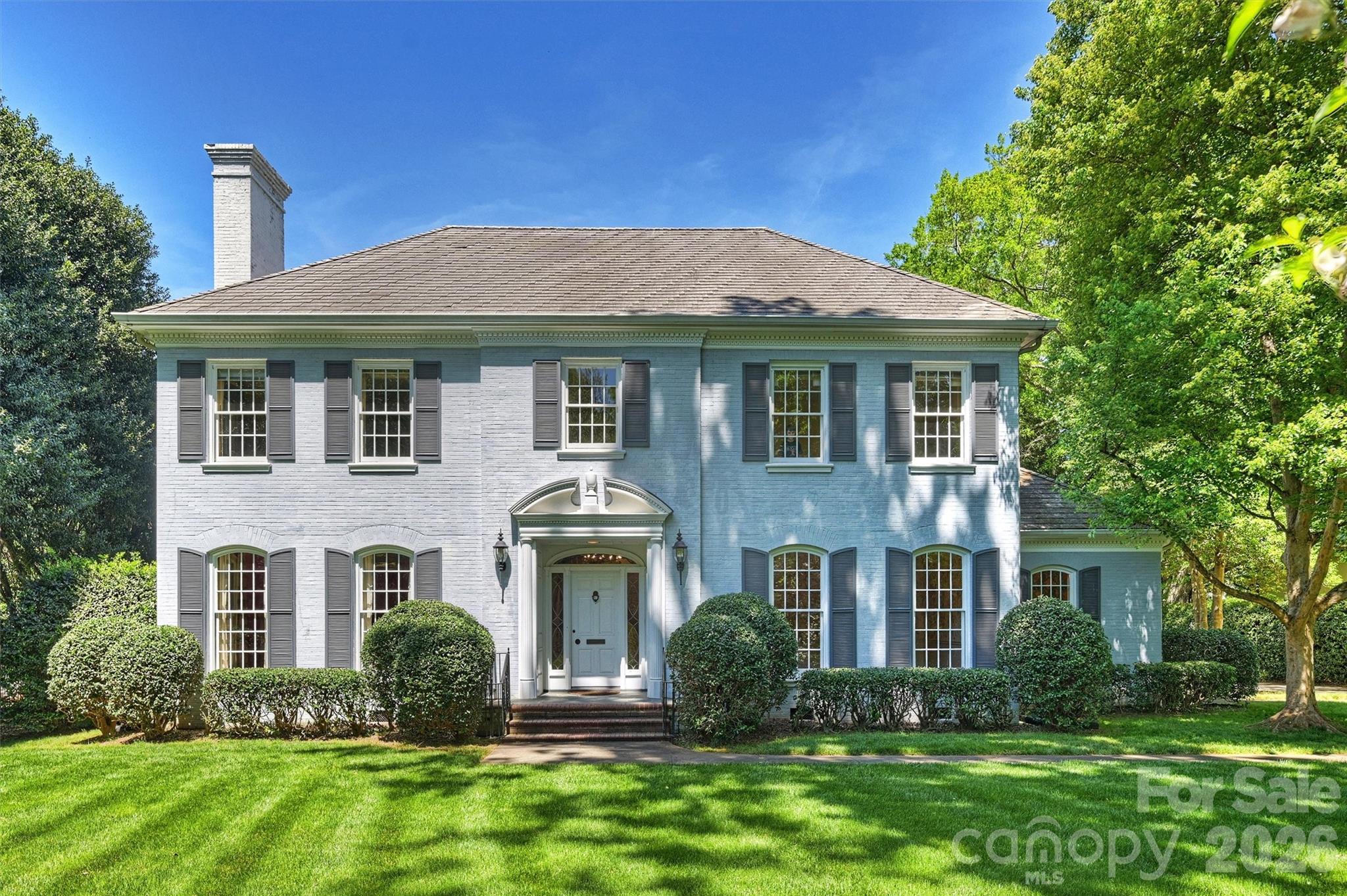 a front view of a house with a yard and trees