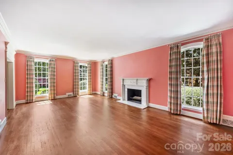 a view of empty room with wooden floor and fireplace