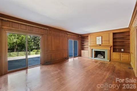 a view of an empty room with a fireplace and a window