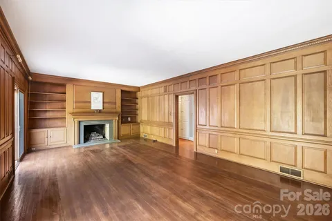 a view of an empty room with a fireplace and a window