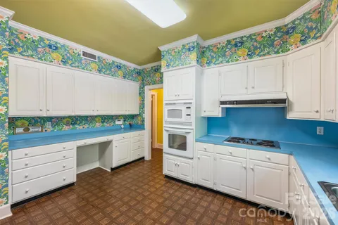 a kitchen with granite countertop white cabinets and white appliances