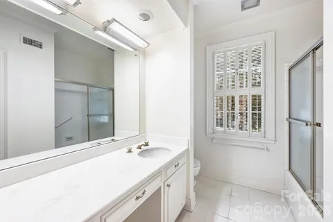 a bathroom with a sink shower and a mirror