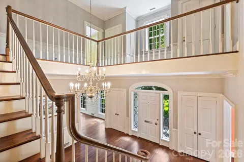 a view of a hallway with wooden floor and staircase