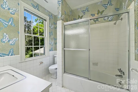 a bathroom with a shower a toilet and a window