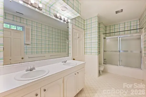 a bathroom with a double vanity sink mirror and shower