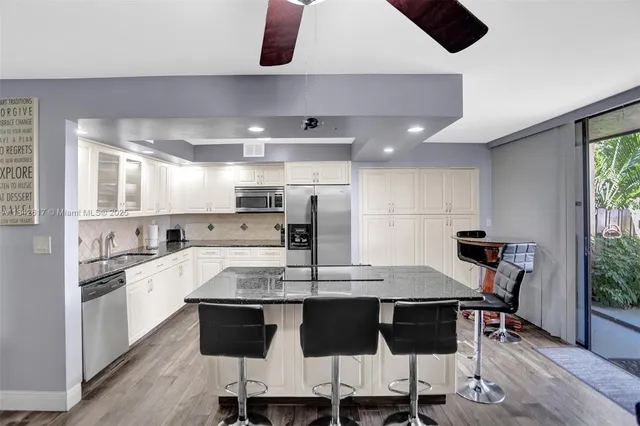 a kitchen with a dining table chairs and white cabinets