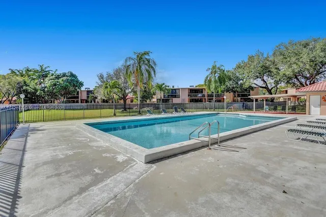 a view of a swimming pool with a yard and a fountain