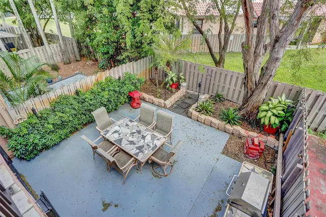 a view of a chairs and table in the back yard