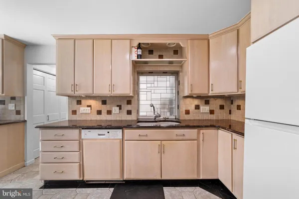 a kitchen with granite countertop white cabinets and white appliances