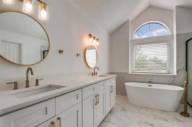 a spacious bathroom with a double vanity sink a mirror and a bathtub