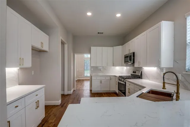 a kitchen with sink a stove and cabinets