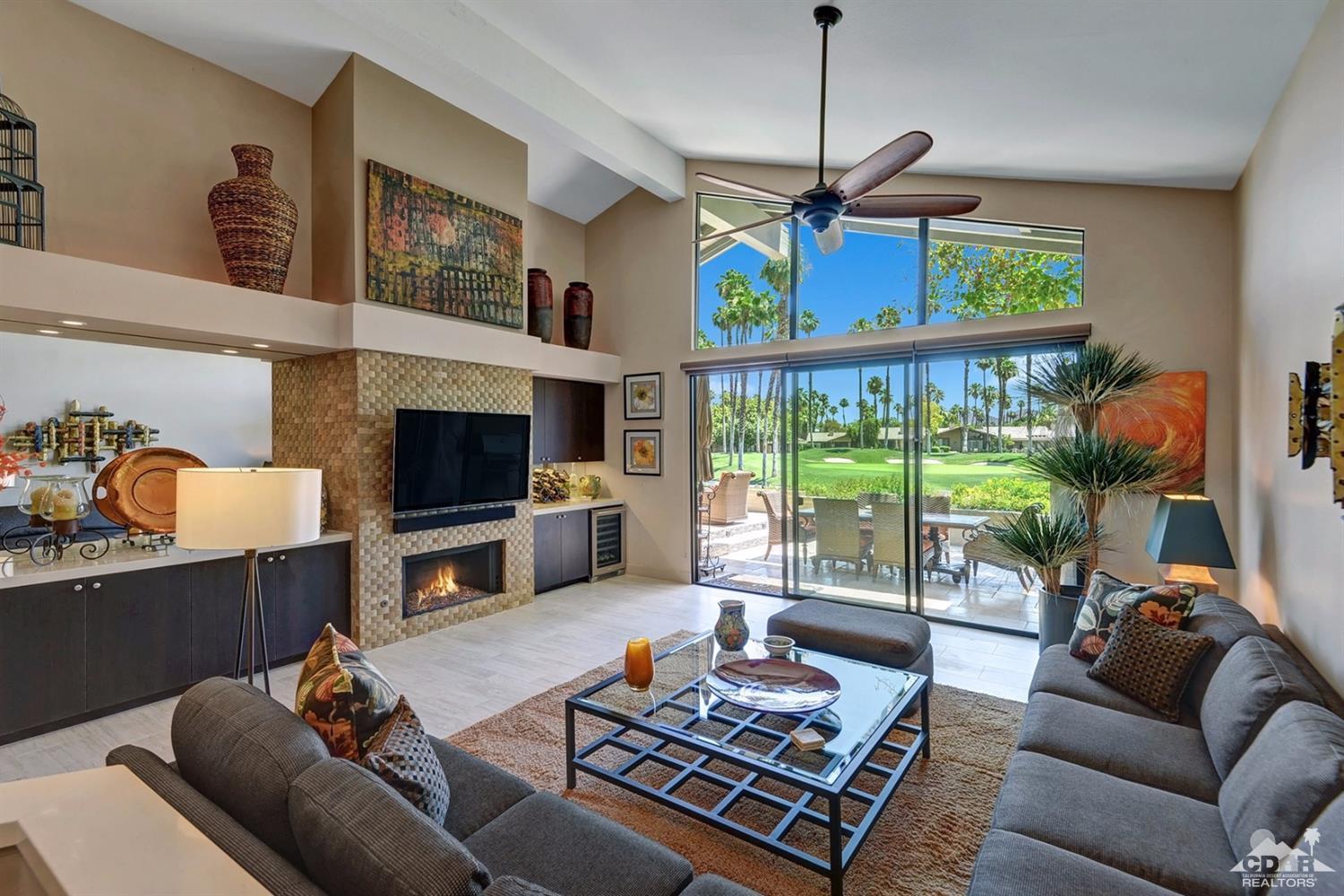 395 Red River Road Palm Desert, CA 92211 - Photo 6 of 29 a living room with furniture a flat screen tv and a floor to ceiling window