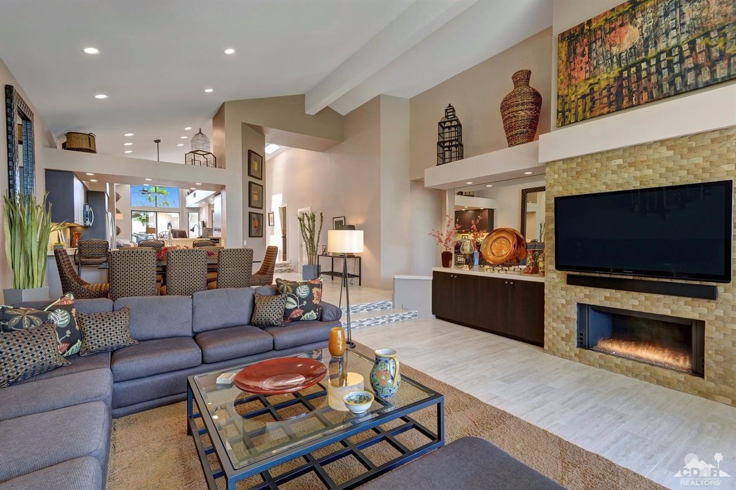 395 Red River Road Palm Desert, CA 92211 - Photo 7 of 29 a living room with furniture a flat screen tv and a fireplace