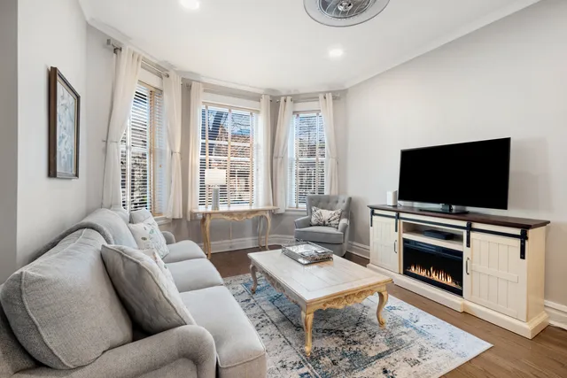 a living room with furniture a flat screen tv and a fireplace