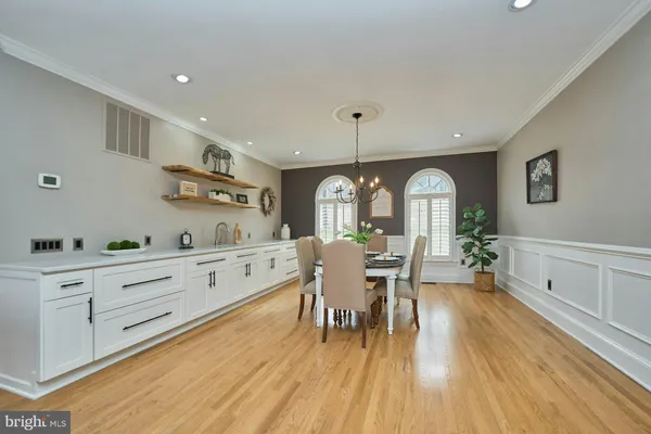 a view of a dining room and livingroom with furniture wooden floor a chandelier